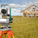 Land surveying equipment in front of a home being built